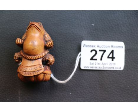 Carved hardwood Japanese netsuke of a seated toad wearing an apron, signed to reverse, height approximately 5cm