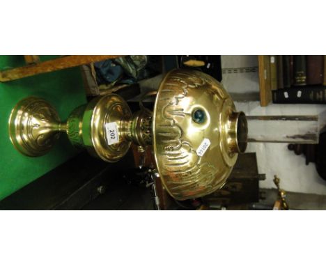 Embossed brass oil lamp with chimney and brass shade.