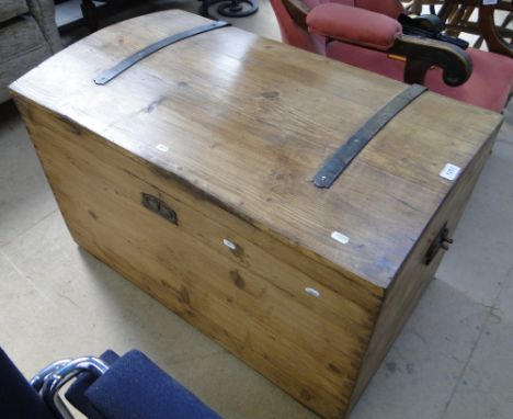 A polished pine dome top trunk.