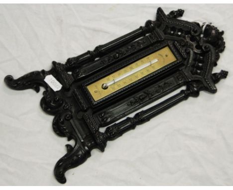 A French brass barometer in carved ebony frame.