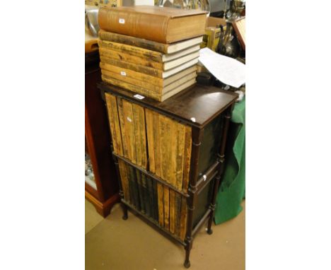 A mahogany book stand with turned columns containing a set of Encyclopedia Britannica 11th Edition, 1911, leather bound.