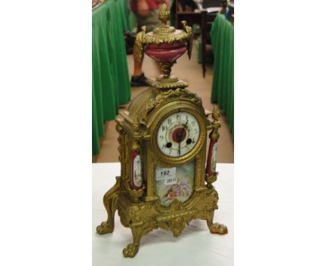 A continental gilded metal mantel clock with porcelain panels and columns.