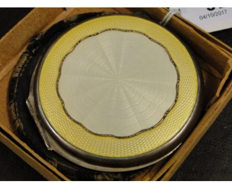 A silver and yellow enamel compact