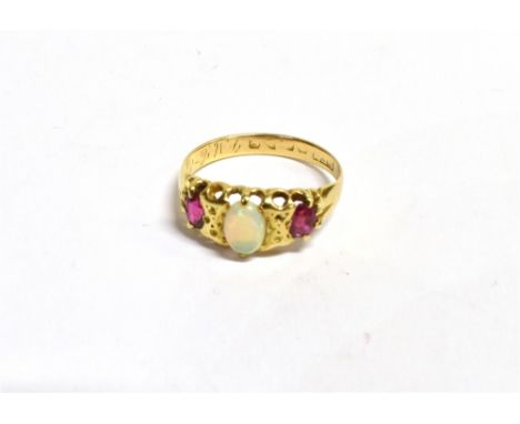 AN OPAL AND RUBY THREE STONE RING the ring centrally set with an oval precious opal measuring 6 x 5mm approx flanked by two o