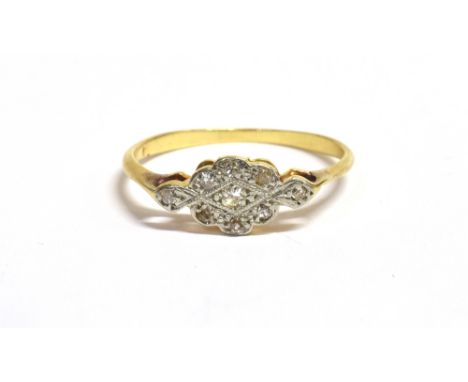 AN ART DECO DIAMOND PLAQUE RING the curved plaque and shoulders set with nine tiny diamonds in white mill grain metal on a ye