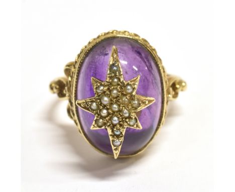 A 9CT GOLD SEED PEARL STAR SET BOULE RING The ring set with a boule of purple garnet glass with a star set seed pearl to the 