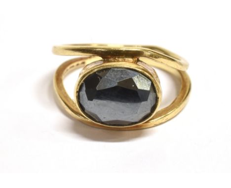 A SMOKEY QUARTZ SOLITAIRE RING The ring horizontally set with a faceted oval quartz stone measuring 9mm X 6 mm the shank of o