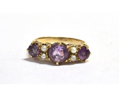 MARKED 9CT PURPLE GARNET AND SEED PEARL DRESS RING Three round cut garnets measuring 1 x 6mm, 2 x 4mm, four seed pearls, ring