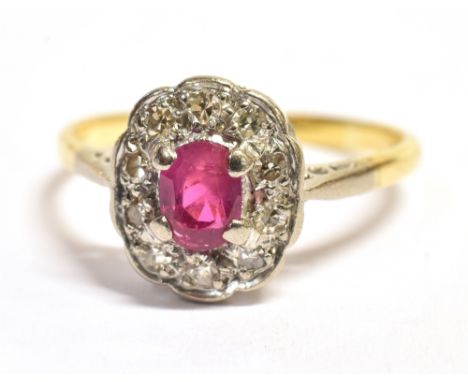 A DIAMOND CLUSTER RING the cluster centrally set in white metal featuring a pink oval faceted stone, possibly a synthetic rub