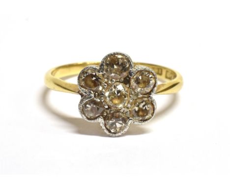 AN ART DECO DAISY DIAMOND RING The ring set with a daisy head comprising of transitional cut diamonds with the central diamon