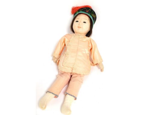 A Chinese doll, with articulated limbs in peach dress, 40cm high.