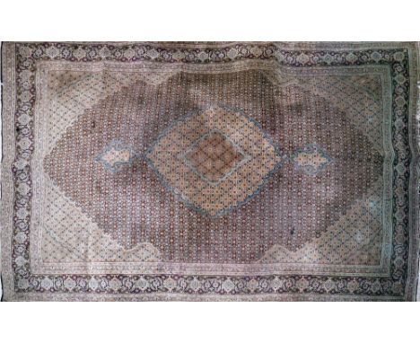 An Indo-Tabriz carpet with central floral medallion surrounded by floral motifs, on a black ground, contained by repeating fl