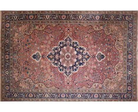 A Kashan carpet with central floral medallion, on a salmon pink ground, contained by floral motifs and borders, 210 x 147cm 