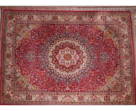 A large Kashan style carpet with central floral medallion, on a red ground, contained by floral border, 266 x 188cm 