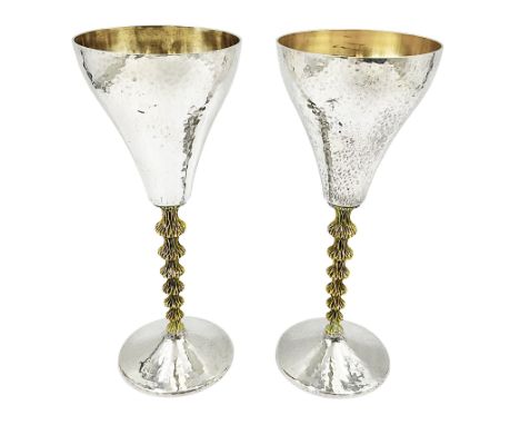 Pair of modern silver goblets by Stuart Devlin, the tapering cylindrical bowls each with spot hammered decoration and gilt in