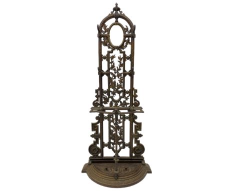 19th century cast iron hallway hat and coat stand, the arched frame decorated with overlapping foliage, central oval mirror s