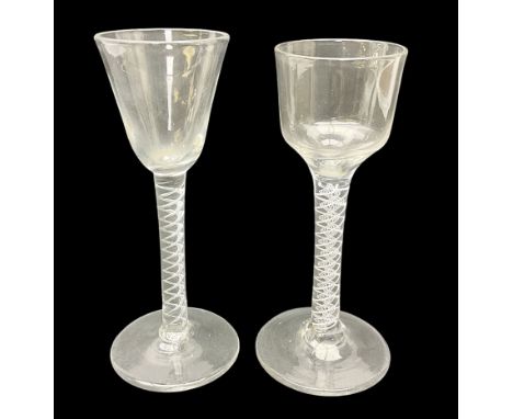 Two 18th century drinking glasses, the first example with ogee shaped bowl upon a double series opaque twist stem and conical