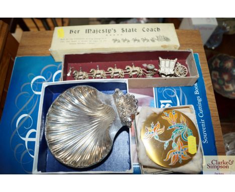 A silver plated shell shaped dish; a compact; Royal commemorative souvenir cutting book and a model of The State Coach