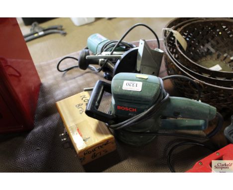 A Bosch POF500A router; a Bosch electric sander; and small wooden case of router bits 