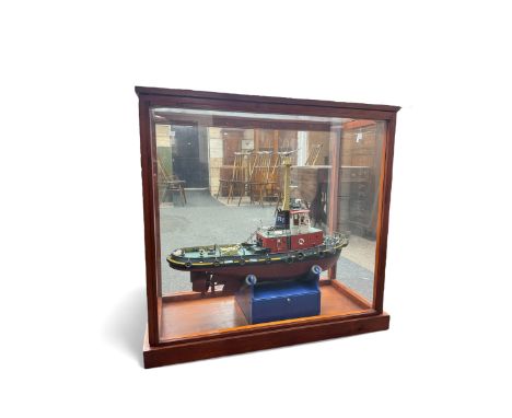 Modern model of Tugboat 'Coral Cove', in red, black and green finish, upon a blue stand, contained within a wooden display ca