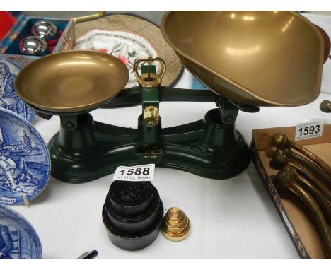 A set of kitchen scales with brass and metal weights. 