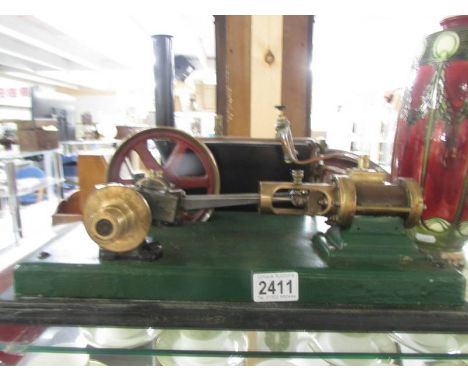 A Stuart Turner steam engine with cylinder and motion wheel.