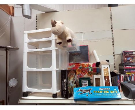 A plastic storage drawers and a selection of toys, model kits and puzzles