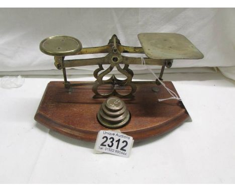A set of brass postal scales with weights. 