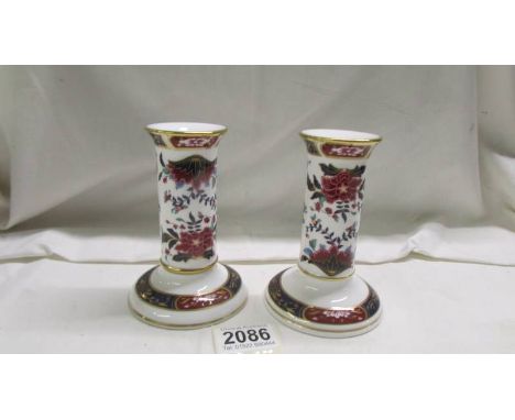 A pair of Royal Worcester porcelain candelsticks.