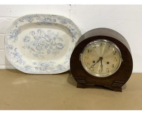 A vintage mantle clock with key and pendulum with a Victorian platter. 