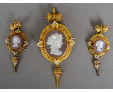 A 19th century unmarked gold enamel decorated hardstone cameo suite
Comprising: a pendant brooch and a pair of earrings.  The