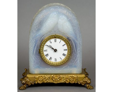 An early 20th century Lalique style opalescent pressed glass mantel clock
The domed case with two birds amongst foliage, the 