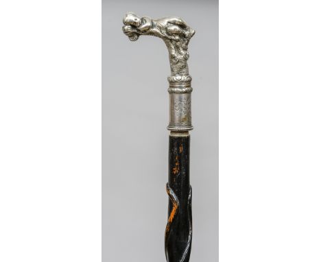 A Victorian walking stick
The ebonised shaft decorated with twin entwined serpents, the silver plated handle formed as a recu