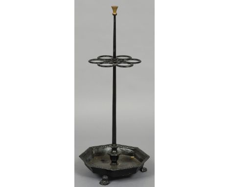 A cast iron sticks stand
Of free standing form with six stick apertures above the octagonal tray form base with paw feet.  10