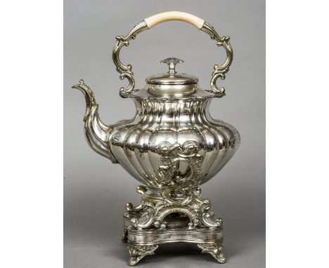 A Victorian silver plated spirit kettle
Of baluster lobed form, the stand with C-scroll cast supports and standing on cast br