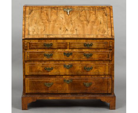 An 18th century walnut bureau
The line inlaid fall enclosing a fitted interior with a baize lined writing surface and a well,