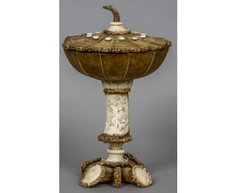 A 19th century carved antler cup and cover
The removable segmented domed cover above segmented bowl above the stem carved wit