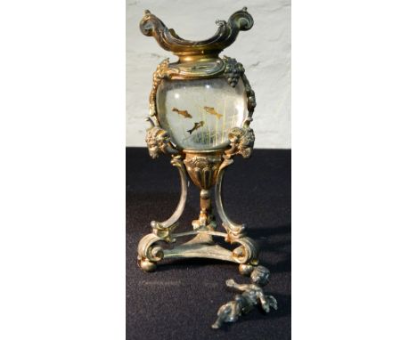 An unusual gilt spelter framed glass model aquarium
The ram's mask and swag decorated stand centred with a glass roundel with