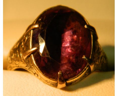 A Georgian unmarked amethyst set ring
The claw set stone above the florally engraved shoulders.  CONDITION REPORTS: Denting a