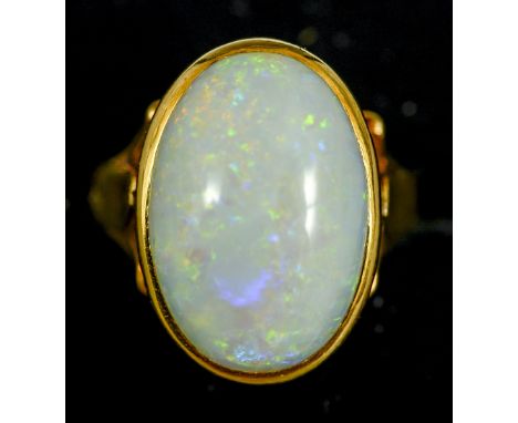 An unmarked 18 ct gold and opal ring
The cabochon stone set above the pierced shoulders.  The stone 2 cm long. CONDITION REPO