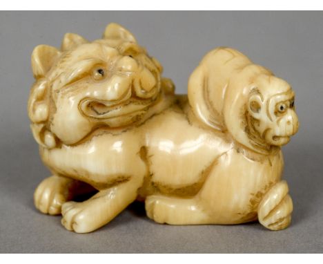 A 19th century Japanese carved ivory netsuke 
Formed as a dog-of-fo with a monkey on its back.  4 cm wide.  CONDITION REPORTS