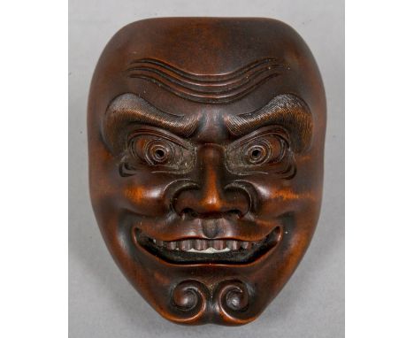A late 19th century Japanese carved wooden netsuke
Modelled as a figural mask.  5.75 cm high. CONDITION REPORTS: Overall good