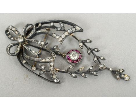 A Victorian unmarked diamond and ruby set pendant brooch
Of pierced trailing foliate form.  8 cm long.  CONDITION REPORTS: Pe