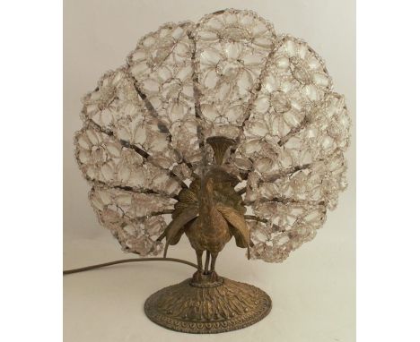 A 1920's/30's gilt metal lamp base, formed as a peacock with the tail being formed as cut clear stones, raised on an oval dom