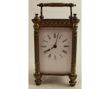 A gilt metal cased carriage clock, with white enamel dial and Roman numerals, height including handle 6ins