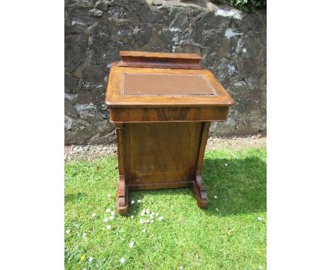 A late 19th century burr walnut Davenport, having stationery section, rising lid and drawers fitted to one side, and with bra