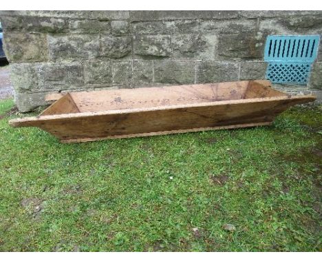 A late 19th century wooden feed or fruit trough, of rectangular form, with canted sides and having two carrying handles at ea