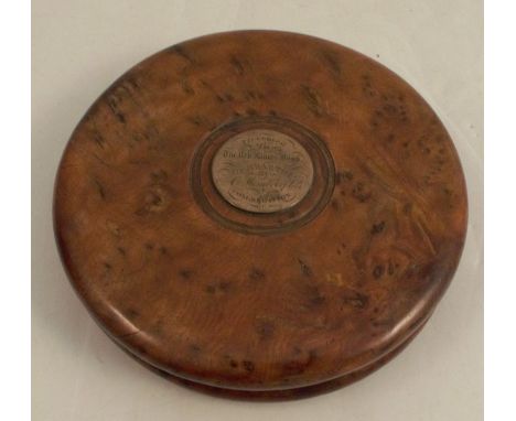 A 19th century burr yew circular snuff box, the top set with a silver plaque engraved Presented to The Rev James Bond Dumbart