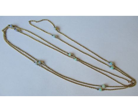 A long chain, in unmarked gold, punctuated at intervals with a total of twelve opal beads, of approximately 5.5mm diameter, c