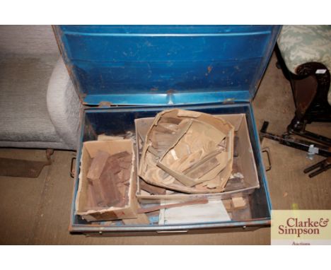 A tin trunk containing various rosewood and ebony off cuts etc